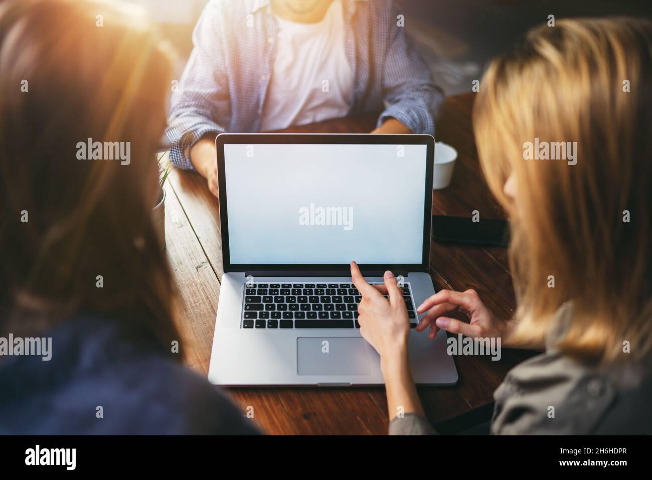 Mockup image of a woman using laptop with blank screen on wooden table ...