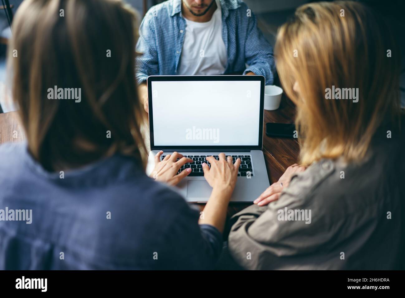 Mockup image of a woman using laptop with blank screen on wooden table ...