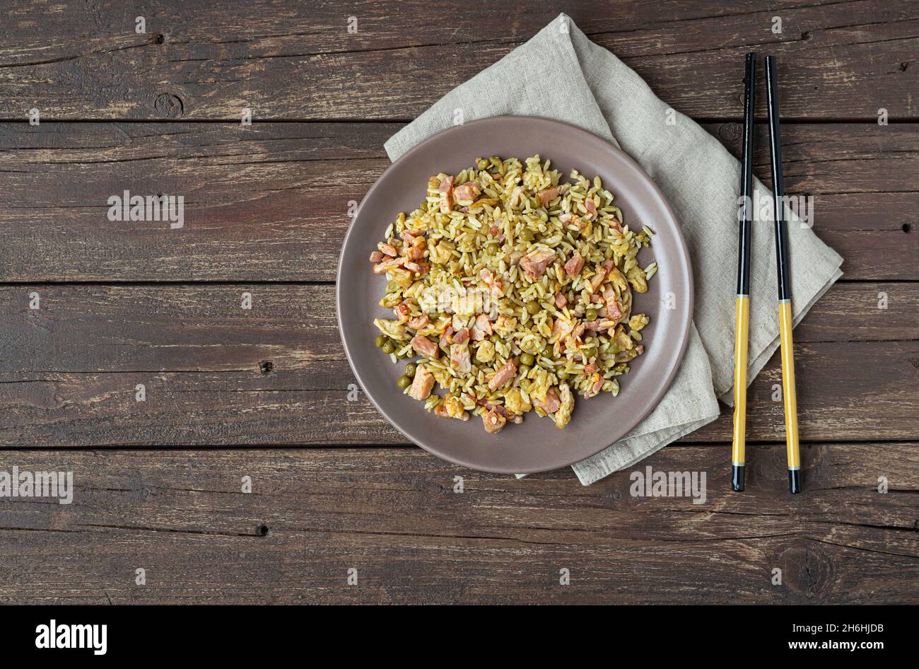 Traditional Cantonese rice or Chinese fried rice in a plate on a dark wooden old table, top view with copy space Stock Photo