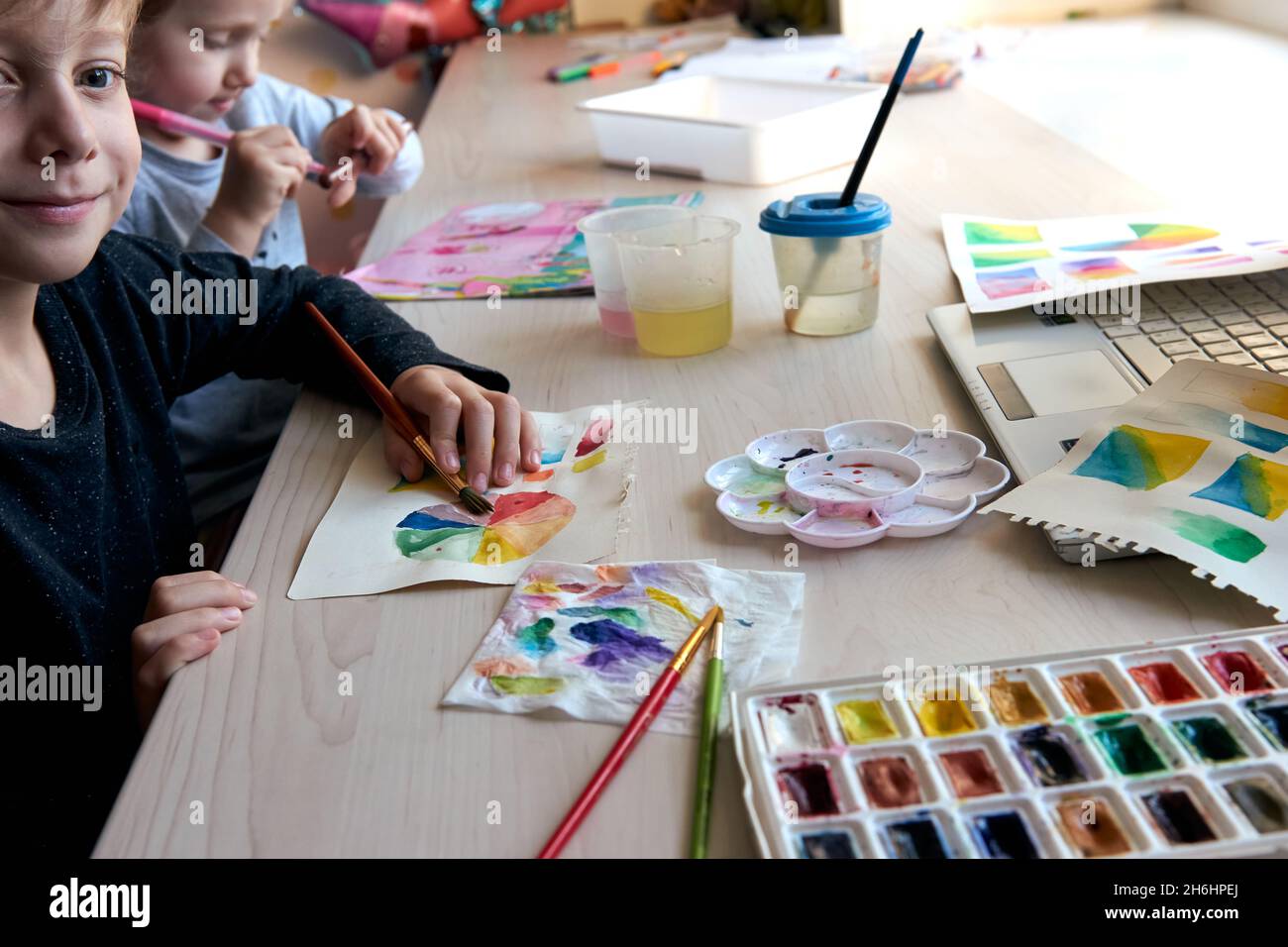 Children painting pictures with watercolor paints during art lesson ...