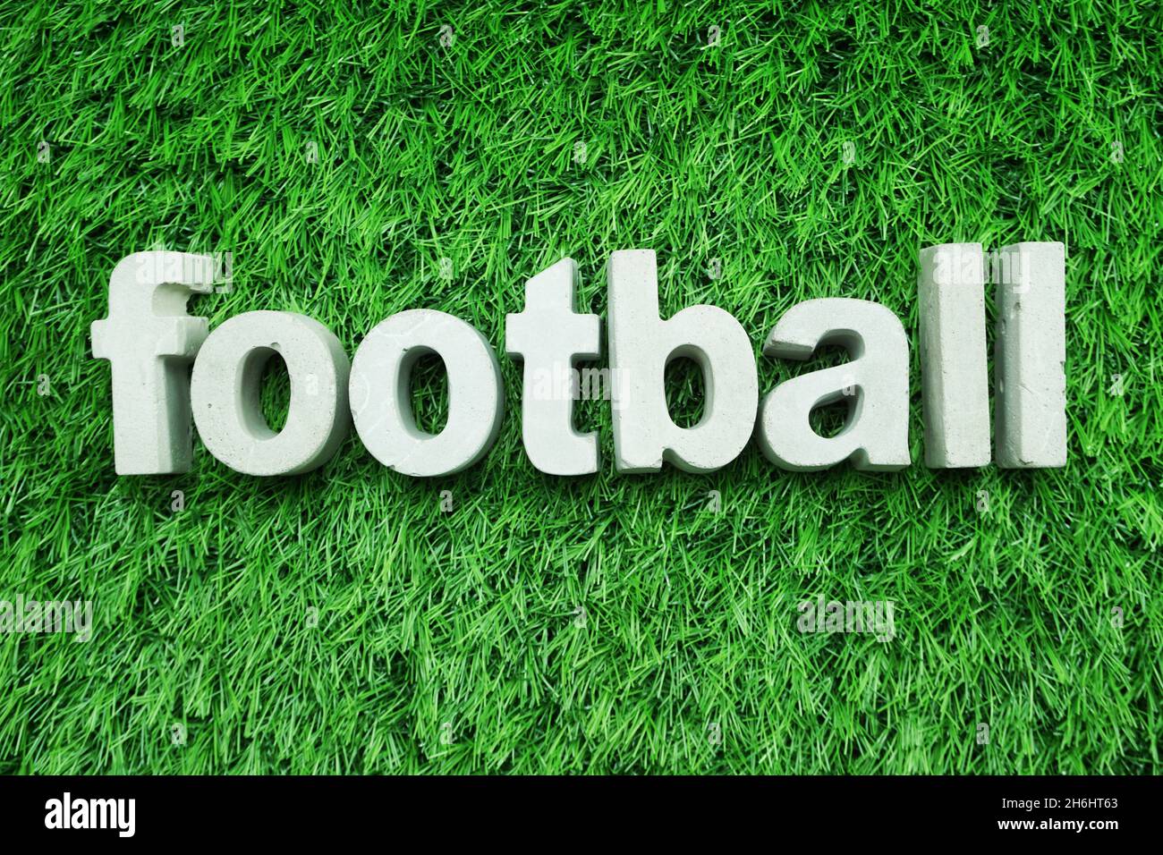 Football made from concrete alphabet top view on green grass Stock