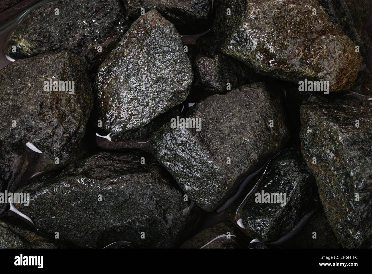 Top view of rough wet granite stones background Stock Photo