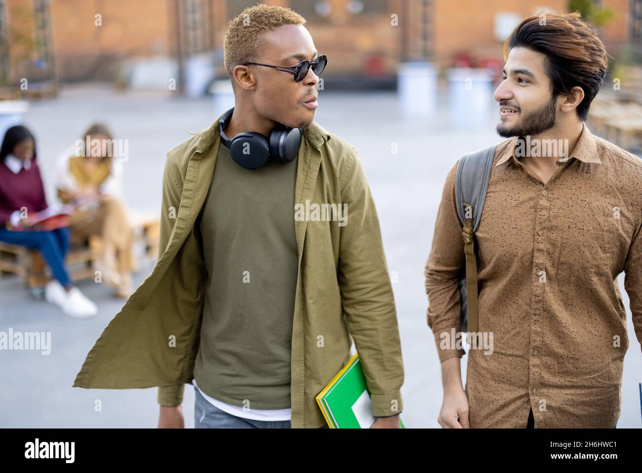 Male students walk and talk at university campus Stock Photo