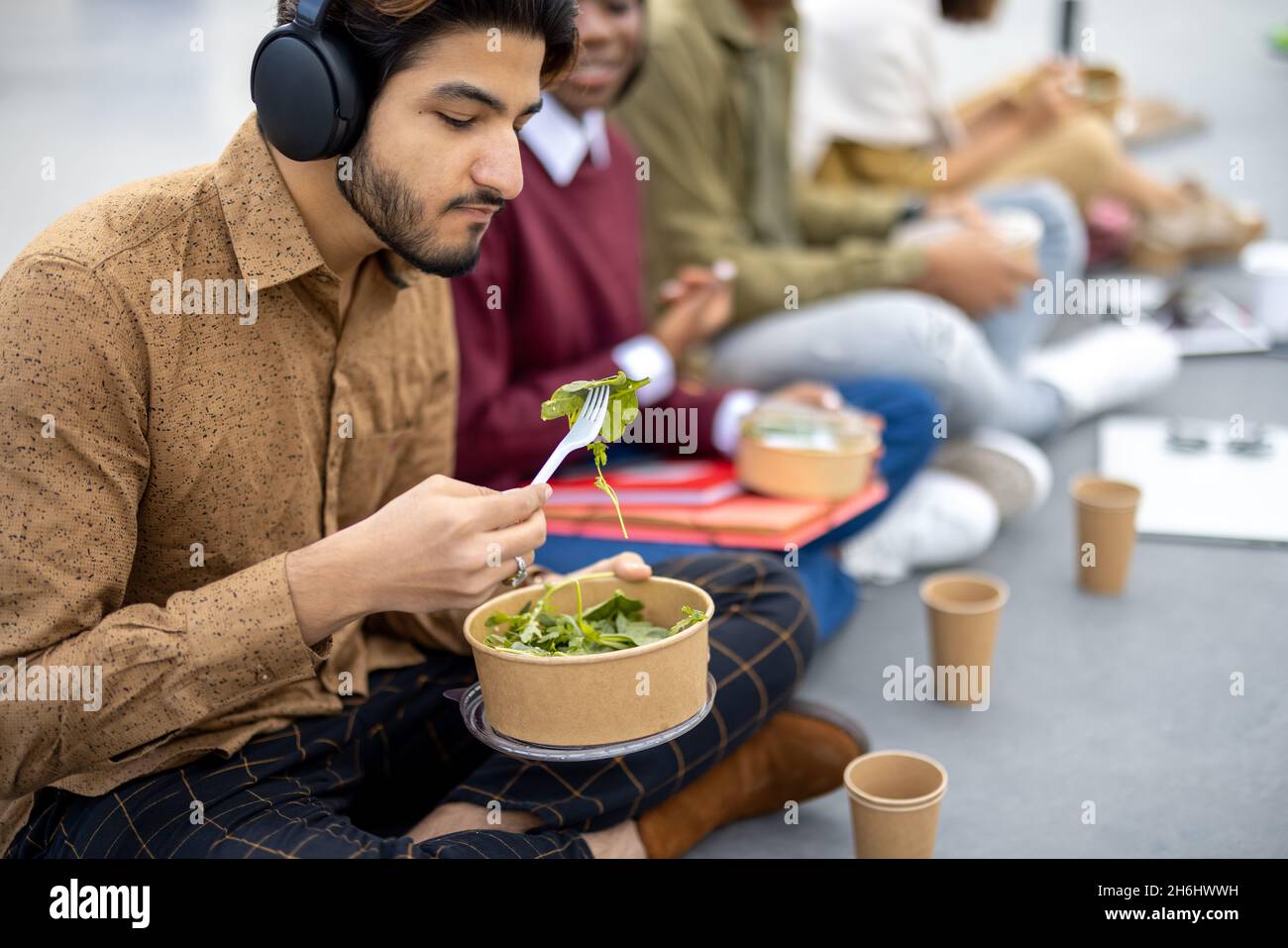 Students eating salad during lunch on asphalt Stock Photo