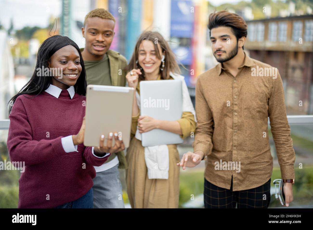 Multiracial students watch some on digital tablet Stock Photo