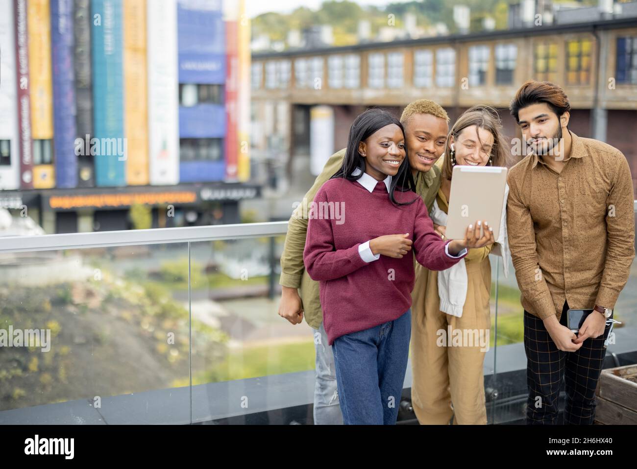 Multiracial students watch some on digital tablet Stock Photo