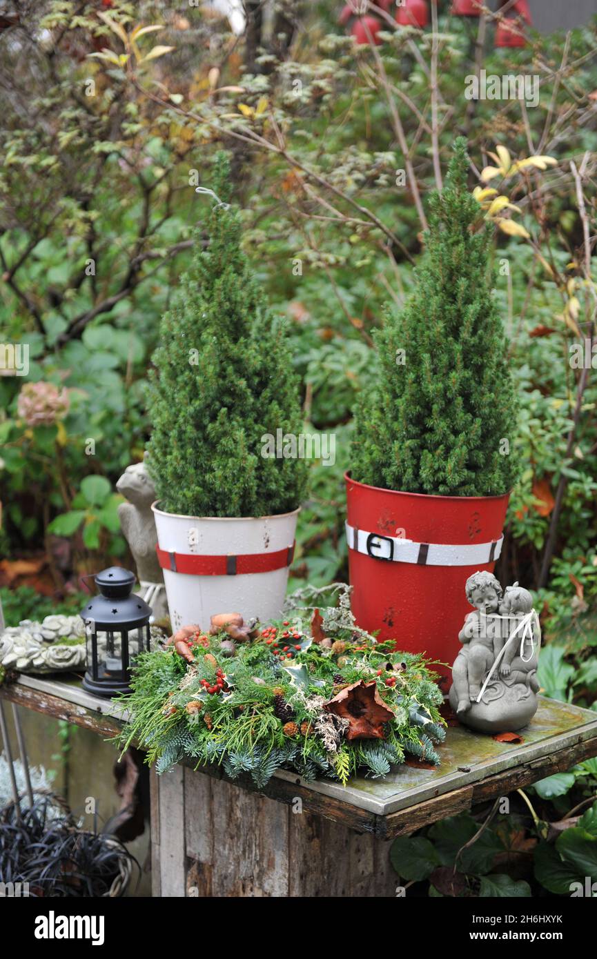Christmas decoration in a garden. Christmas wreath made of false cypress and fir on a wooden table Stock Photo