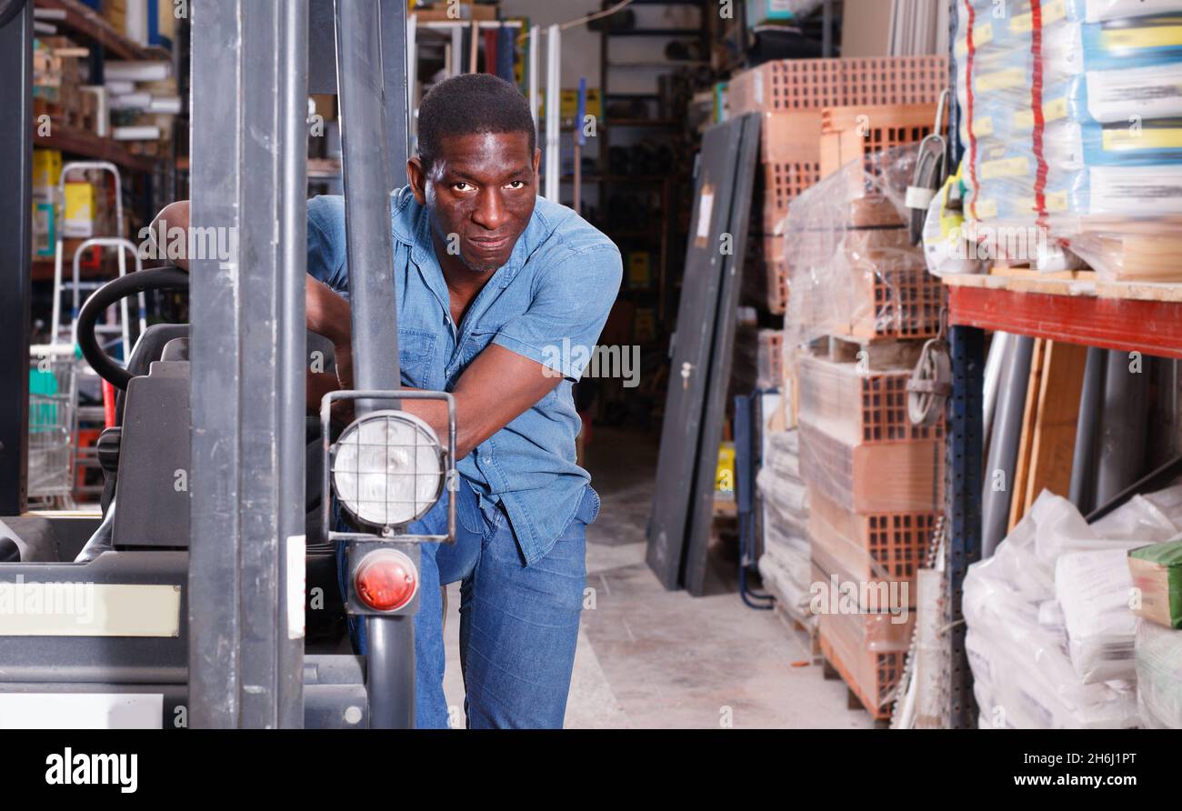 African American worker of building materials warehouse working on ...