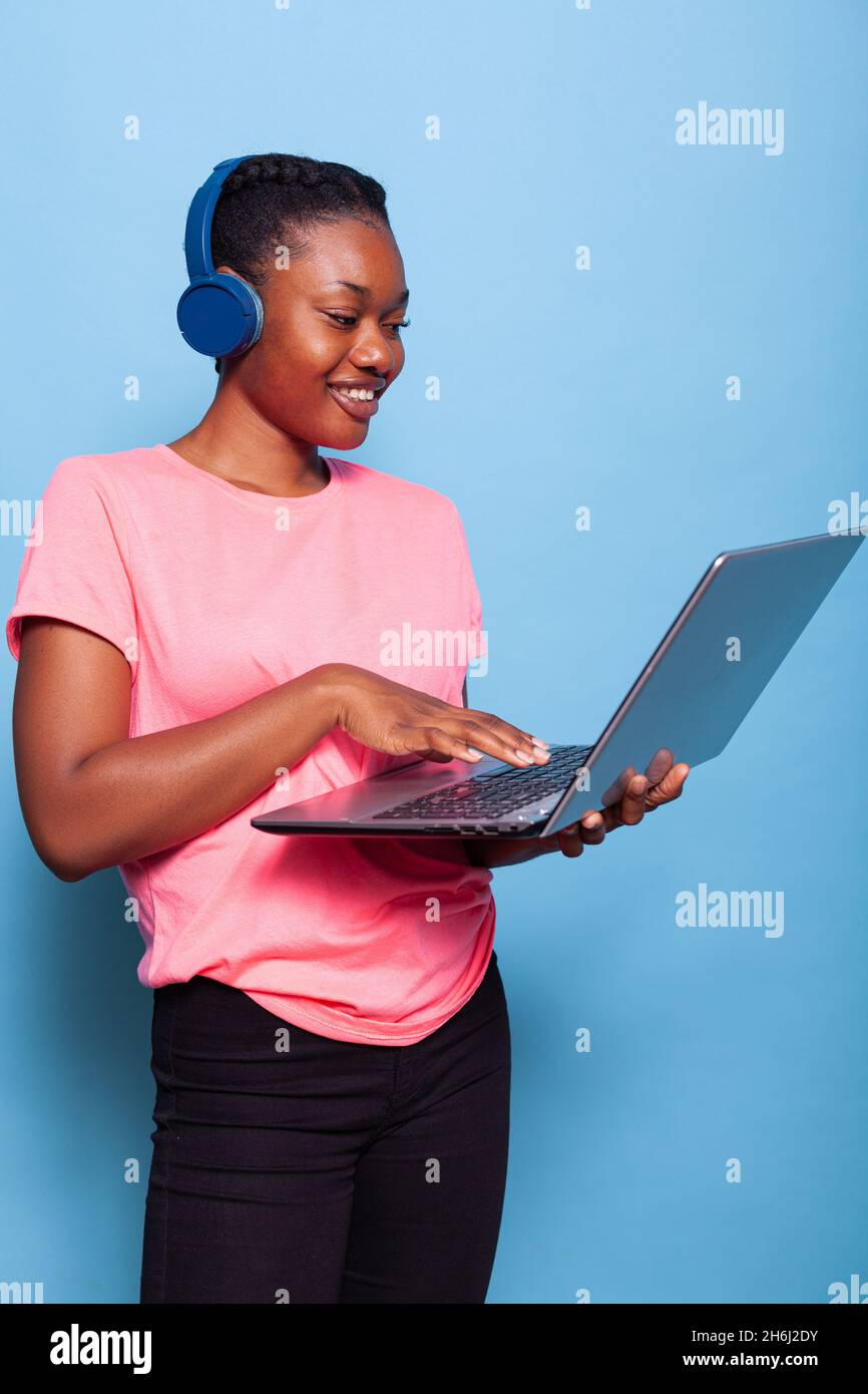 Portrait of african american student with headphones listening music ...