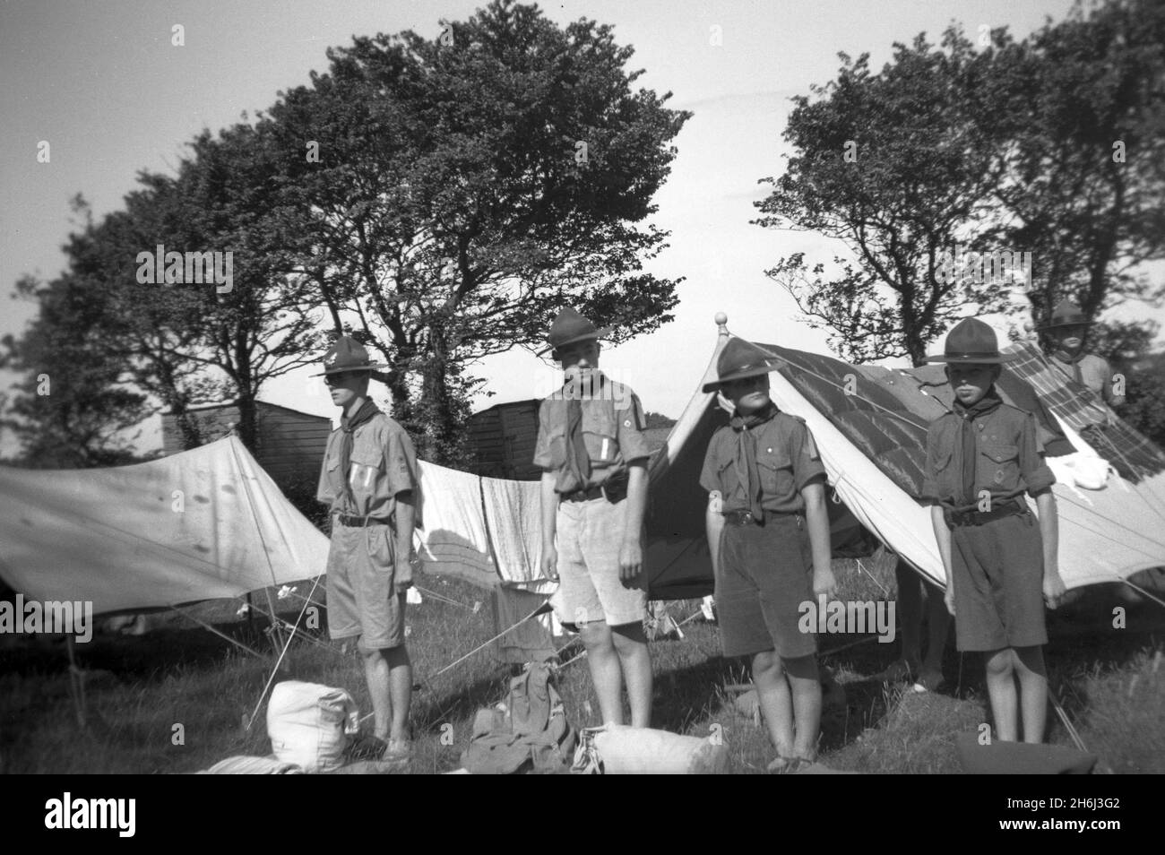 1938, historical, scout camp, outside their tents, a stags inspection,  boy scouts standing in their uniform and scout hats, Ringmore, Devon, England, UK, A stags or scout patrol is traditionally a small team of boy scouts who learn skills, responsibilities and leadership. Scouting began in 1908, after Britsh Army Officer, Robert Baden-Powell held an experimental camp on Brownsea Island, Poole Harbour, the previous summer. Around 20 boys attended and were taught a range of outdoor skills. Baden-Powell's famous and best-selling book, 'Scouting for Boys', was first published in 1908. Stock Photo