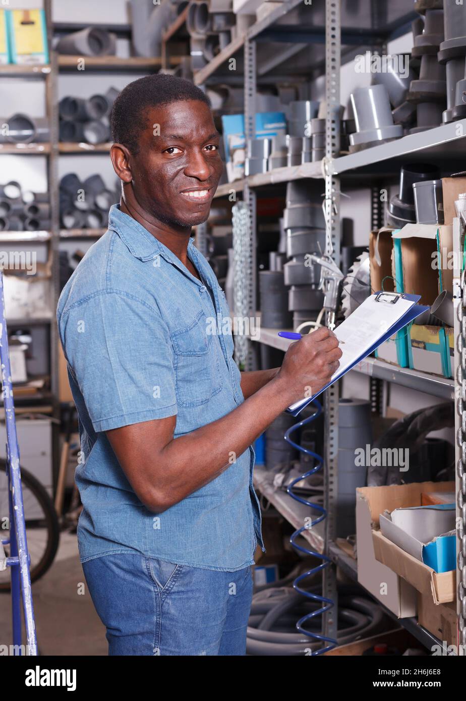 Smiling African American male making inventory Stock Photo - Alamy