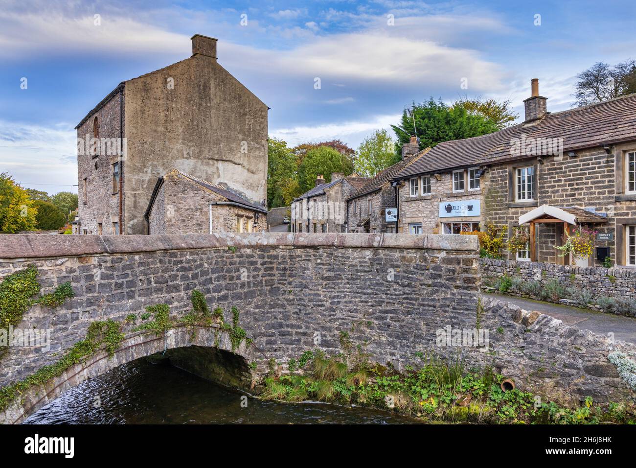 Bridge over Peakshole Water, a stream flowing through the picturesque village of Castleton to join the River Noe, in the Peak District. Derbyshire. Stock Photo