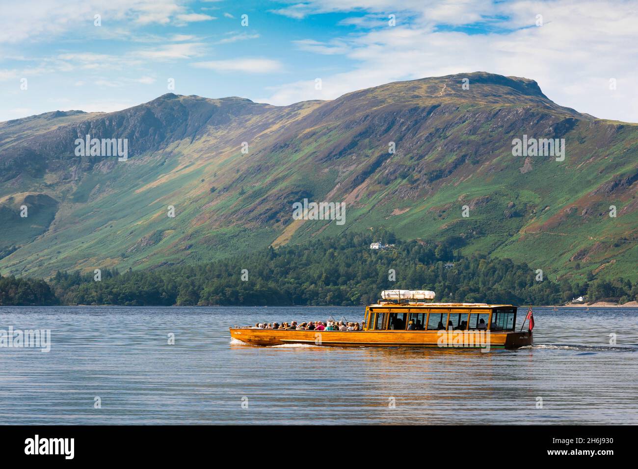 Lake District tourism, summer morning view of a ferry boat cruising Derwent Water with a view of the high Derwent Fells in the distance, England UK Stock Photo