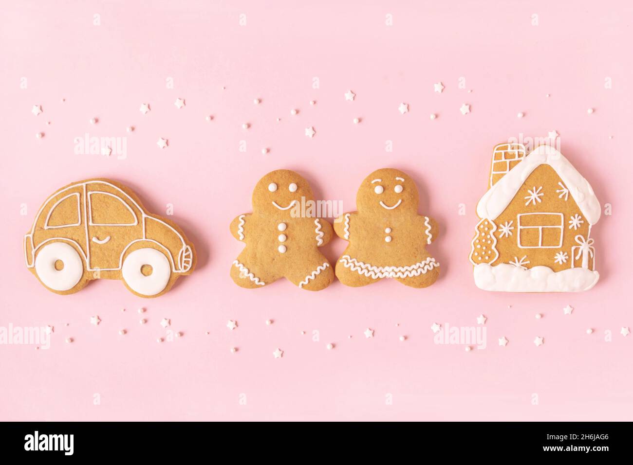 Happy New Year or Christmas card, gingerbread couple - man and woman, house, car and white stars on pink background. Happy family concept Top view. Fl Stock Photo