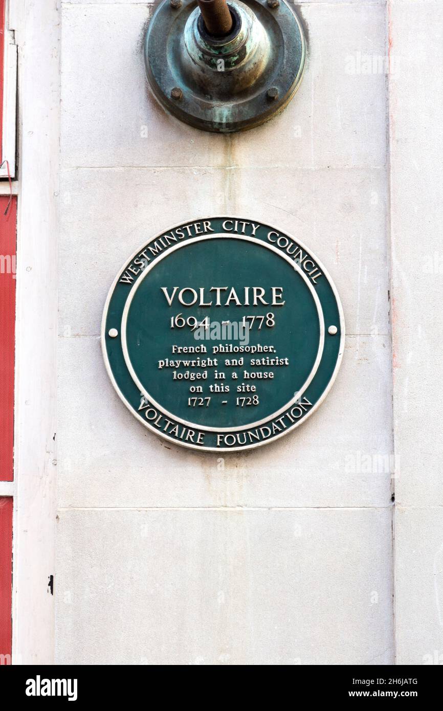 Green heritage plaque marking the lodge house where French philosopher Voltaire lived on Maiden Lane, London, UK Stock Photo