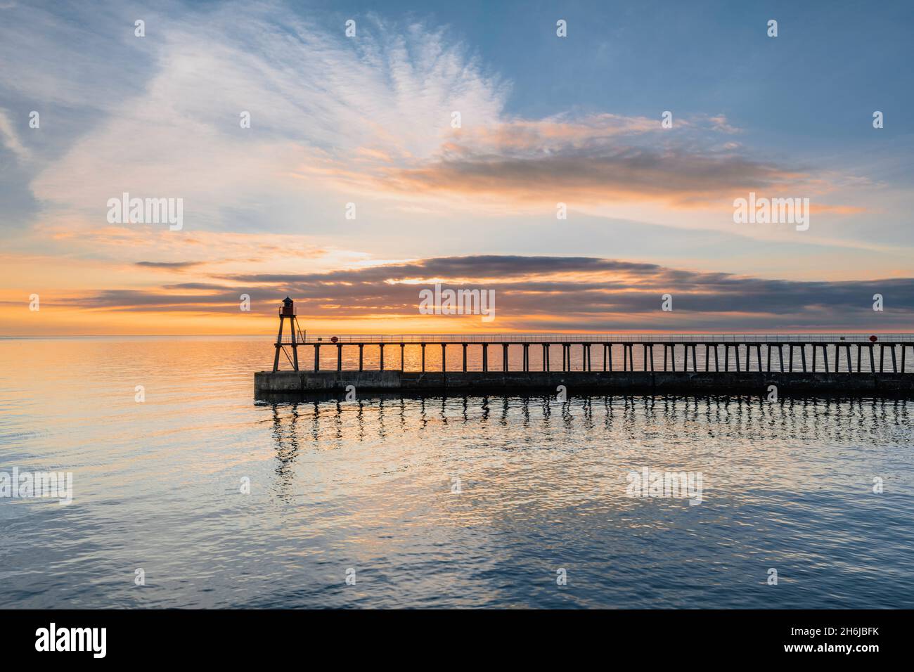Wide view across to the eastern pier and lighthouse at Whitby harbour Stock Photo