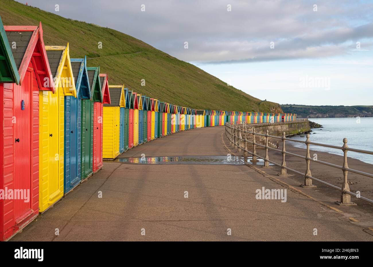 Row of colourful wooden beach huts along the promenade at Whitby Stock Photo