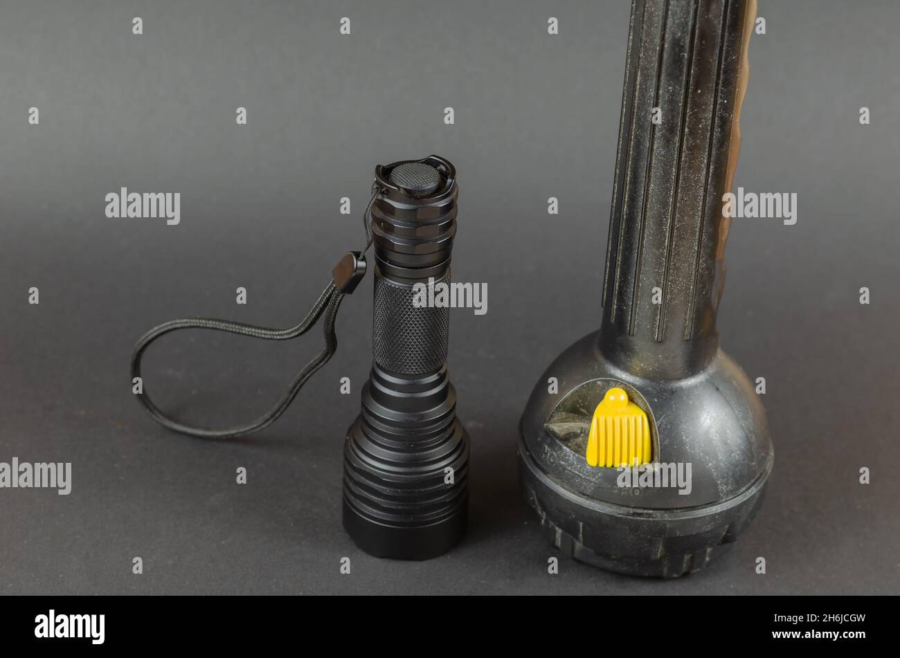Small Modern tactical and large obsolete flashlights on gray background. Selective Focus. Stock Photo