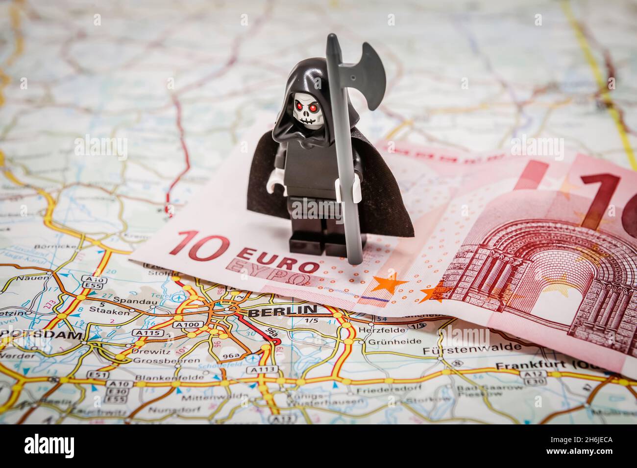 Death of the Euro - The grim reaper standing on a 10 Euro note on top of a map of Europe Stock Photo