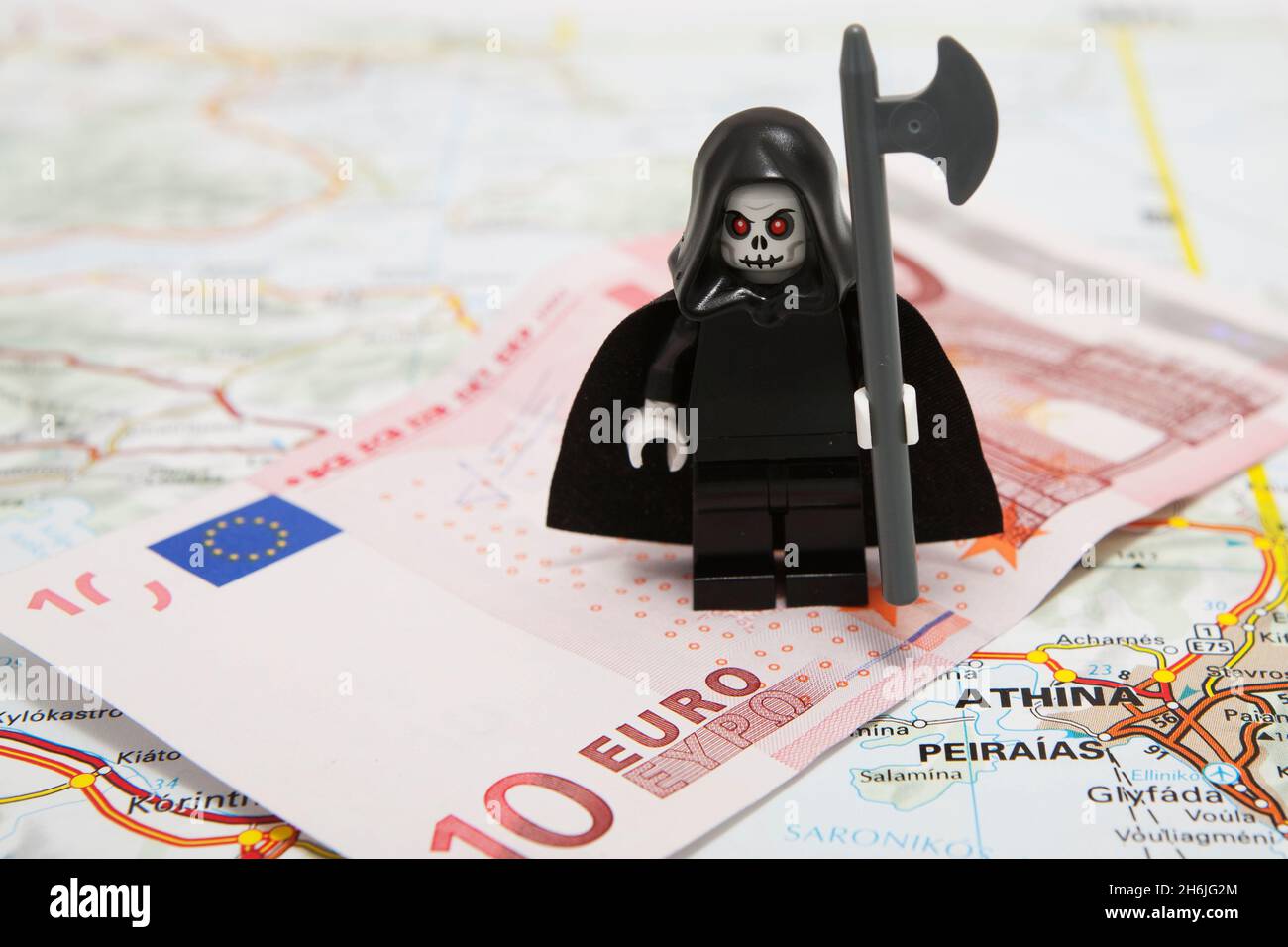 Death of the Euro - The grim reaper standing on a 10 Euro note on top of a map of Europe (Athens, Greece) Stock Photo