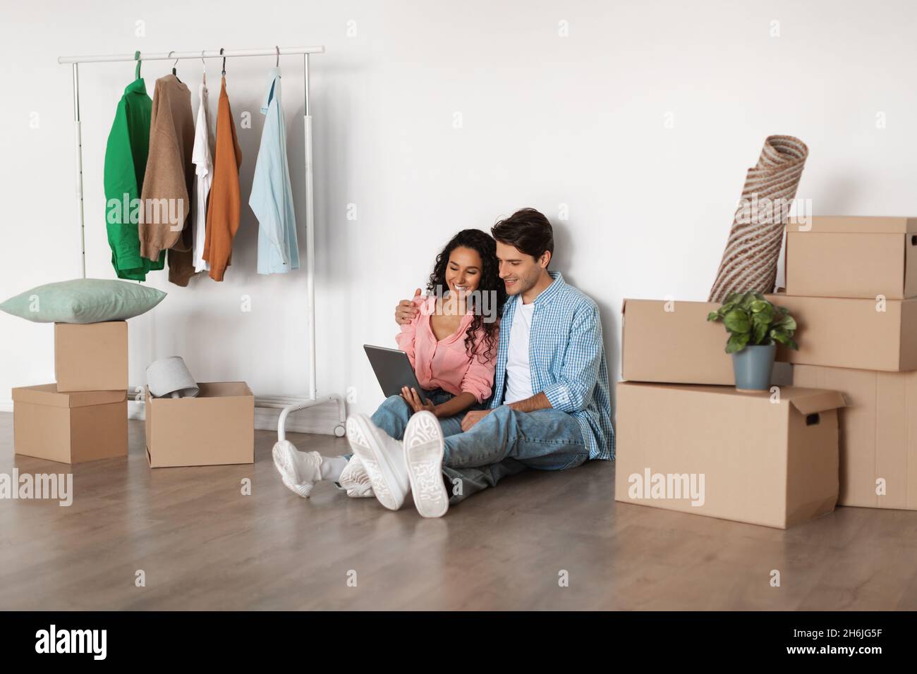 Happy couple using digital tablet after relocation Stock Photo