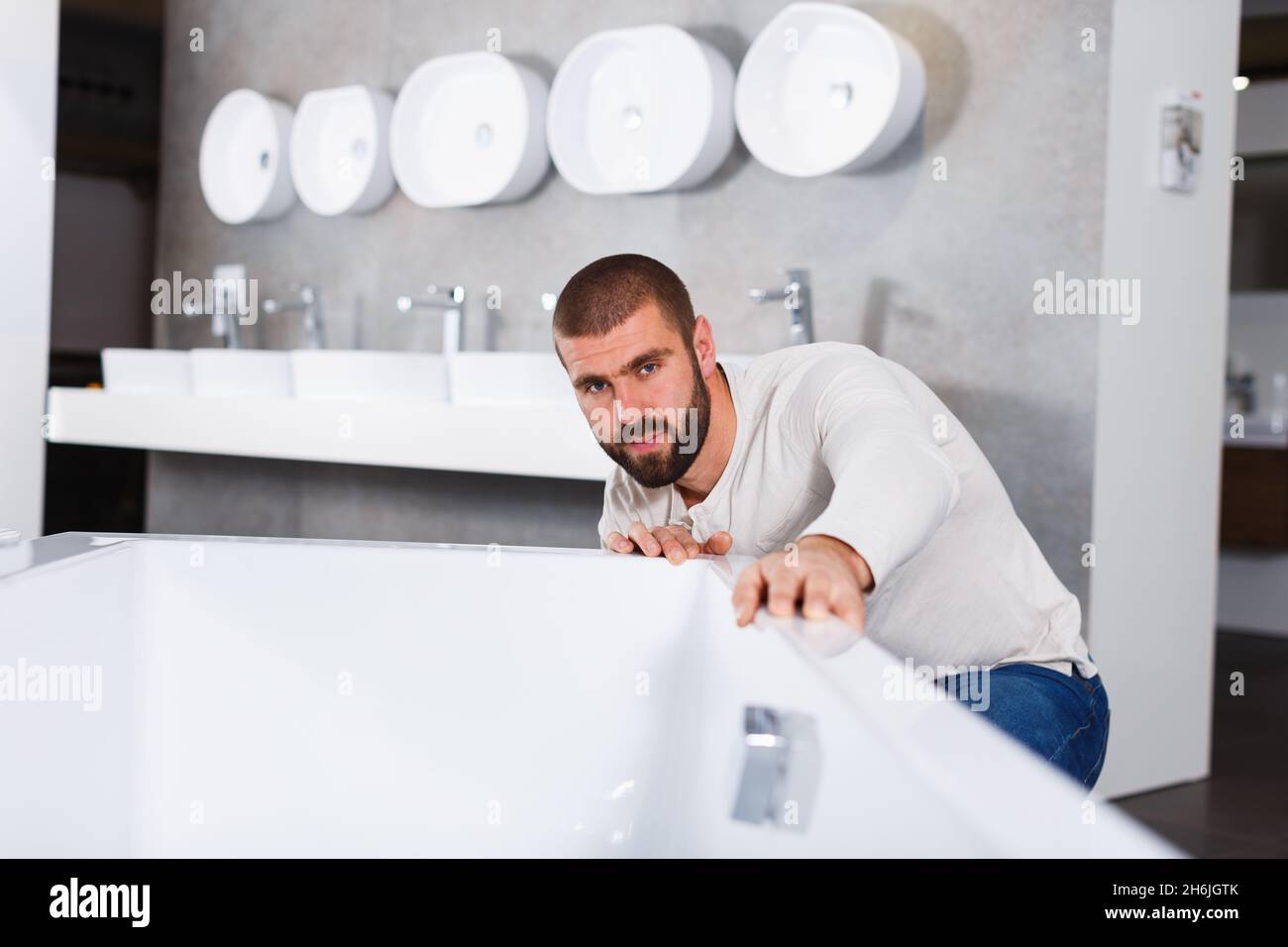 Man choosing ceramic bath in bathroom furniture store Stock Photo Alamy