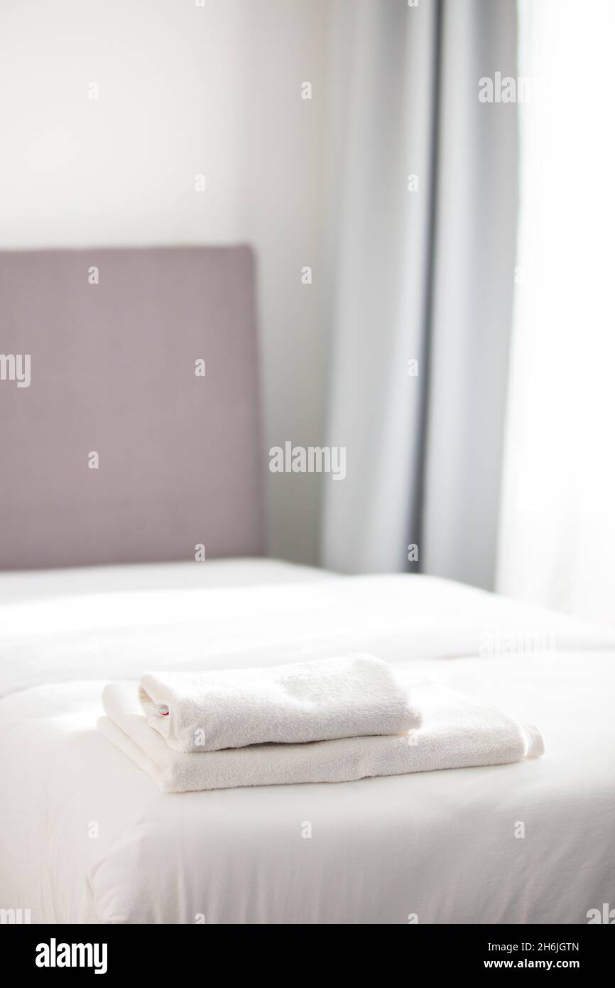 https://c8.alamy.com/comp/2H6JGTN/white-clean-towels-stacked-on-the-hotel-bed-2H6JGTN.jpg
