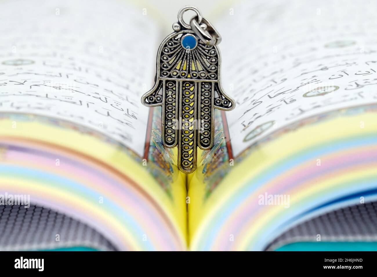 Open Holy Quran with Hamsa (Hand of Fatima) symbols of Muslim faith and religion, France, Europe Stock Photo
