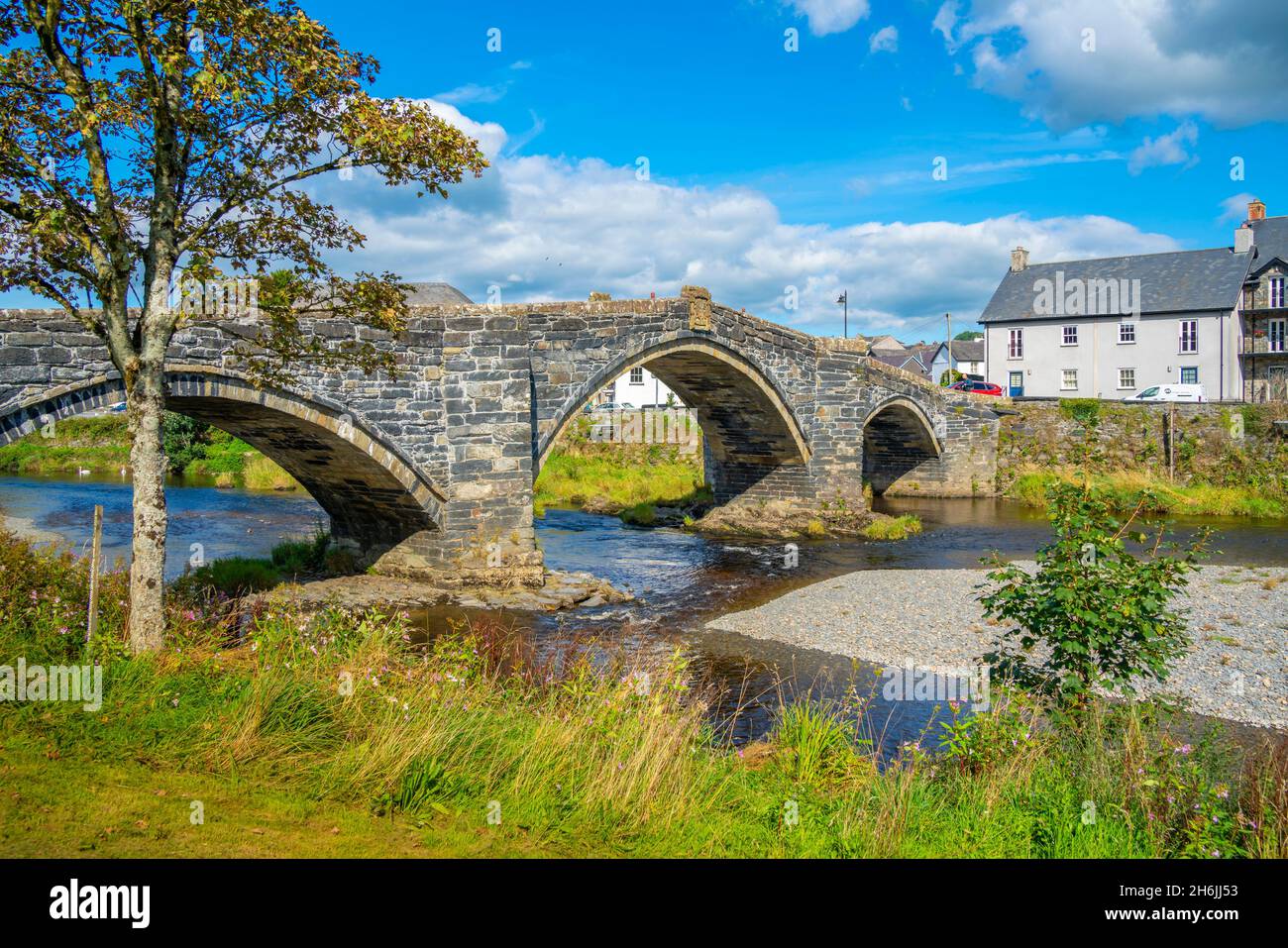 View of Pont Fawr (Inigo Jones Bridge) over Conwy River and riverside houses, Llanrwst, Clwyd, Snowdonia, North Wales, United Kingdom, Europe Stock Photo