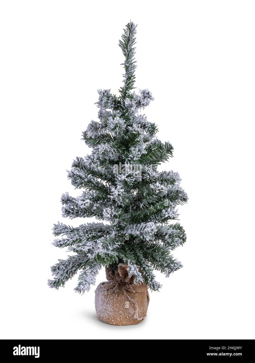 Fake Christmas tree with fake snow on branches. Roots covered in brown