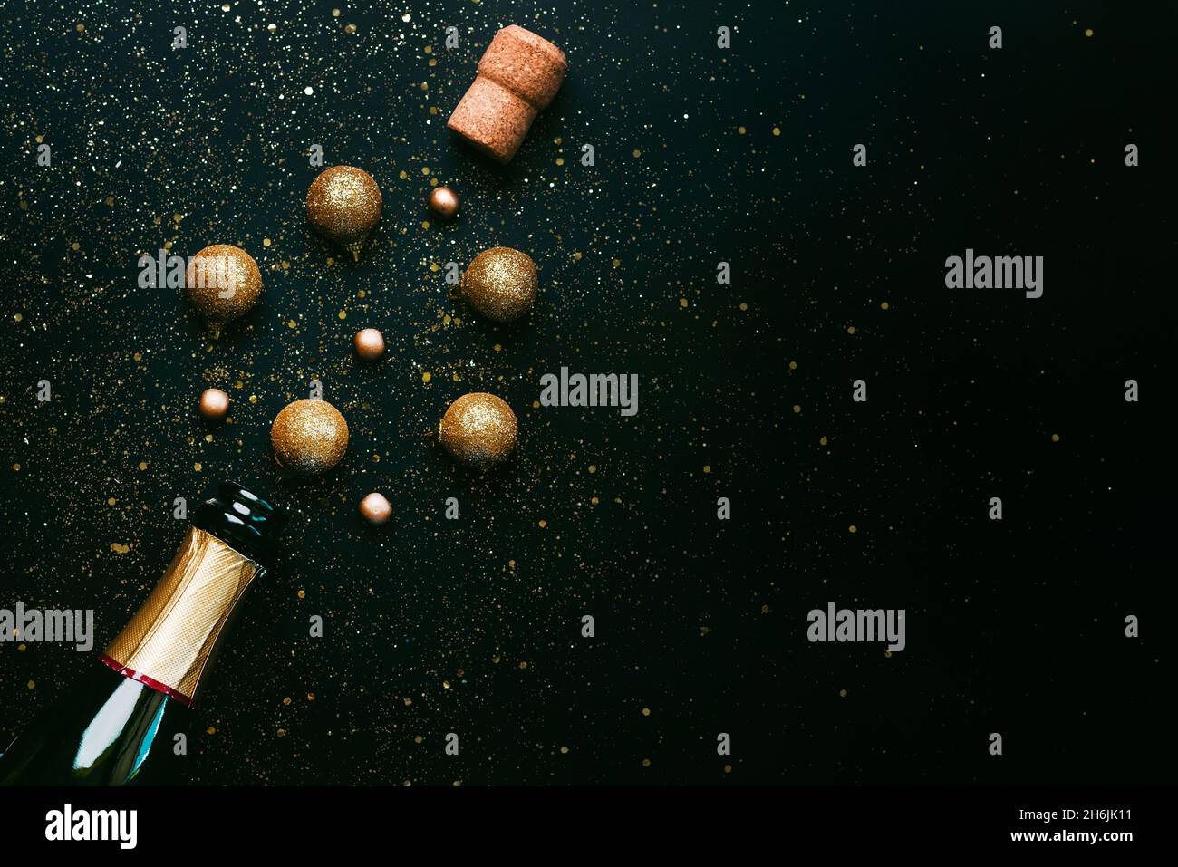 Happy New Year. Champagne bottle and Christmas balls,sparkling Glitter with space for text over black background. New Years Eve celebration concept ba Stock Photo