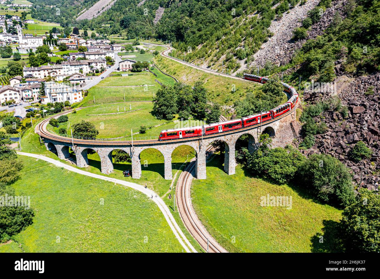 Aerial of a Train crossing the Brusio spiral viaduct, UNESCO World Heritage Site, Rhaetian Railway, Switzerland, Europe Stock Photo