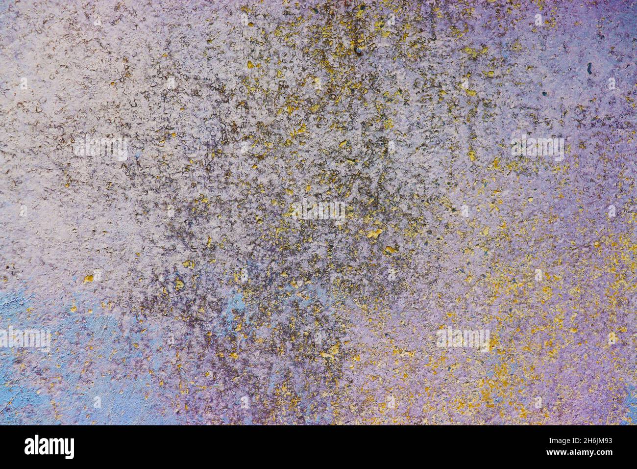 Old wall with colored layers of paintings (yellow, blue, pink and gray), textured background. Stock Photo