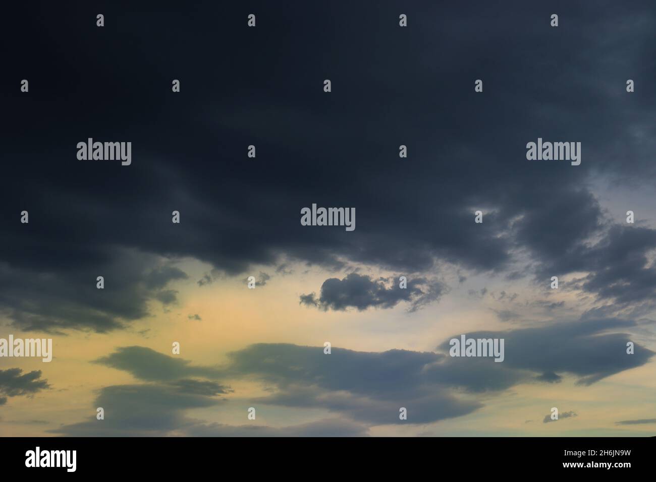Stormy sky full of dark clouds, covering the sunset light, before the rain. Stock Photo