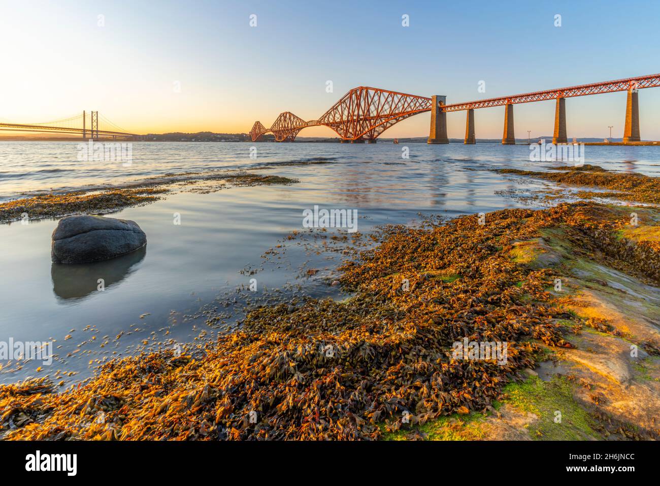 View of the Forth Road Bridge, Queensferry Crossing and Forth Rail Bridge, UNESCO, over the Firth of Forth at sunset, South Queensferry, Edinburgh Stock Photo