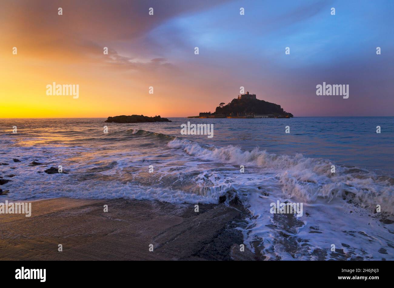 St Michaels Mount Mounts Bay Marazion Cornwall Kernow England at dawn castle silhouetted against sky copy space sea surf waves rocks Stock Photo