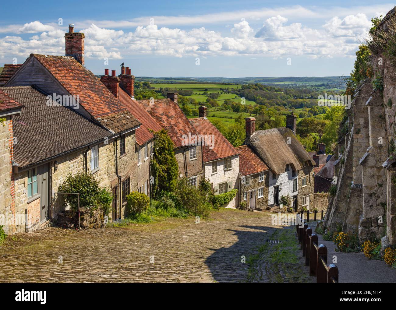 Gold Hill, cobbled lane lined with cottages and views over countryside, Shaftesbury, Dorset, England, United Kingdom, Europe Stock Photo