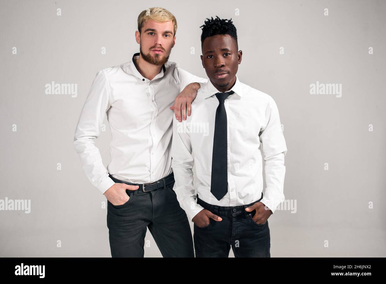 two stylish men posing and having fun on white background 2H6JNX2