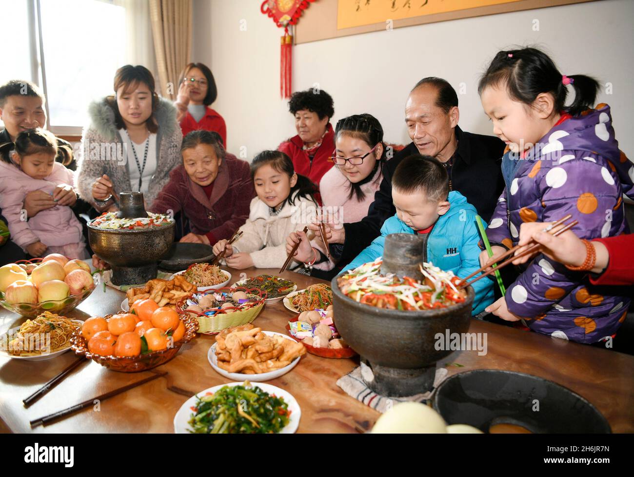 (211116) -- YINCHUAN, Nov. 16, 2021 (Xinhua) -- Xie Xingchang (2nd R) and his family enjoy a family reunion dinner in Minning Town of Yinchuan, northwest China's Ningxia Hui Autonomous Region, Jan. 24, 2020. (Xinhua/Wang Peng) Stock Photo