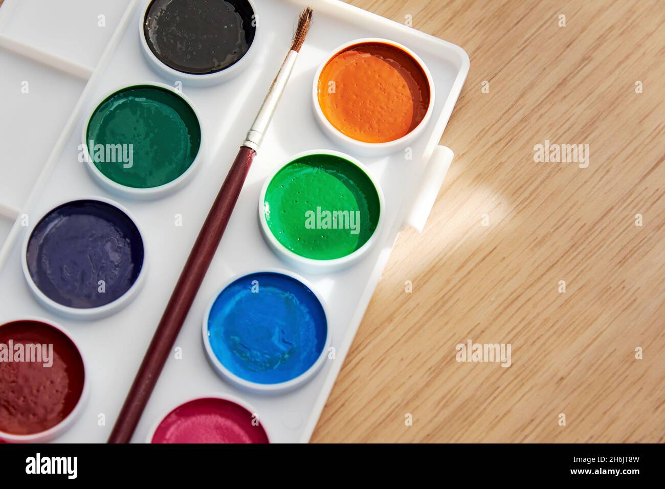 Palette with vivid paints and brush - close-up view. Arts and hobby backgrounds Stock Photo