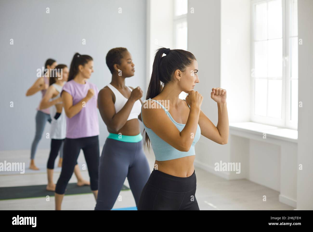 Diverse group of confident women doing physical exercise during sports workout at gym Stock Photo