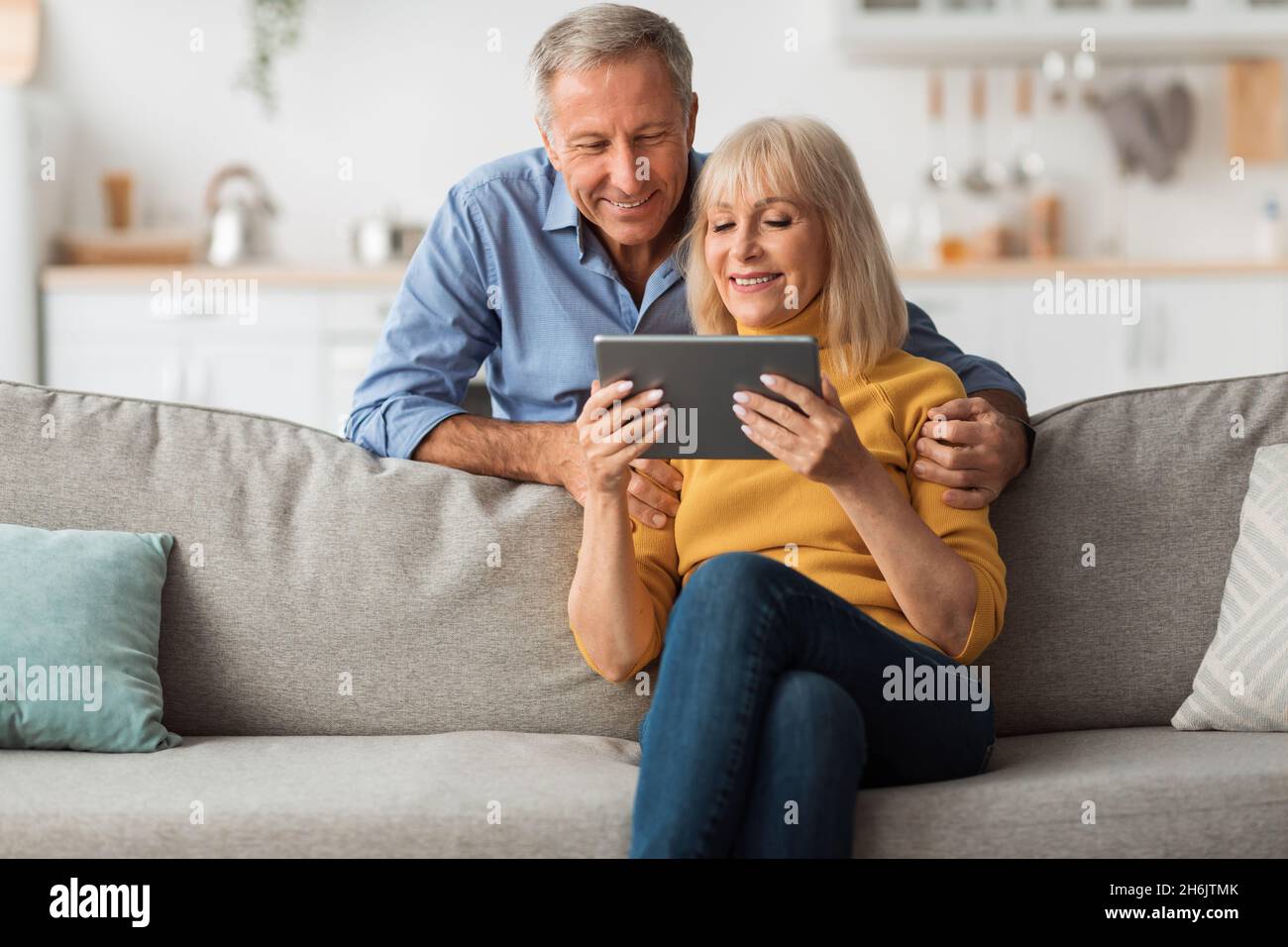 Happy Senior Couple Using Digital Tablet Browsing Internet At Home Stock Photo