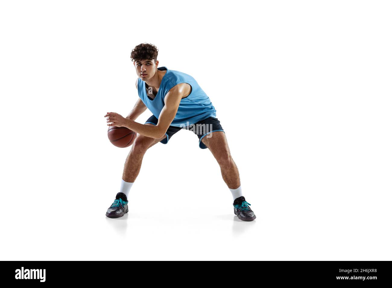 Dynamic portrait of basketball player practicing isolated on white