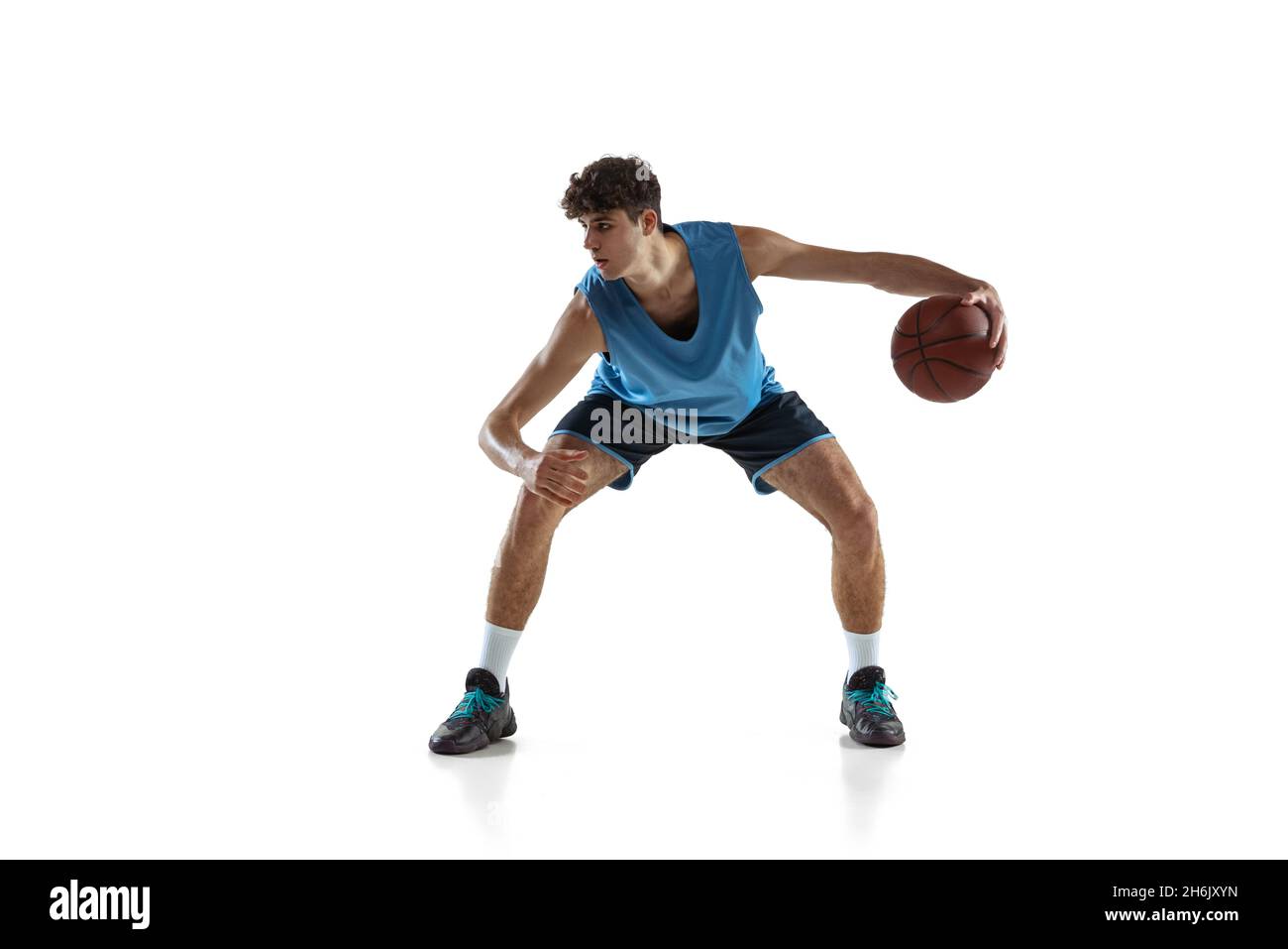 Dynamic portrait of basketball player practicing isolated on white