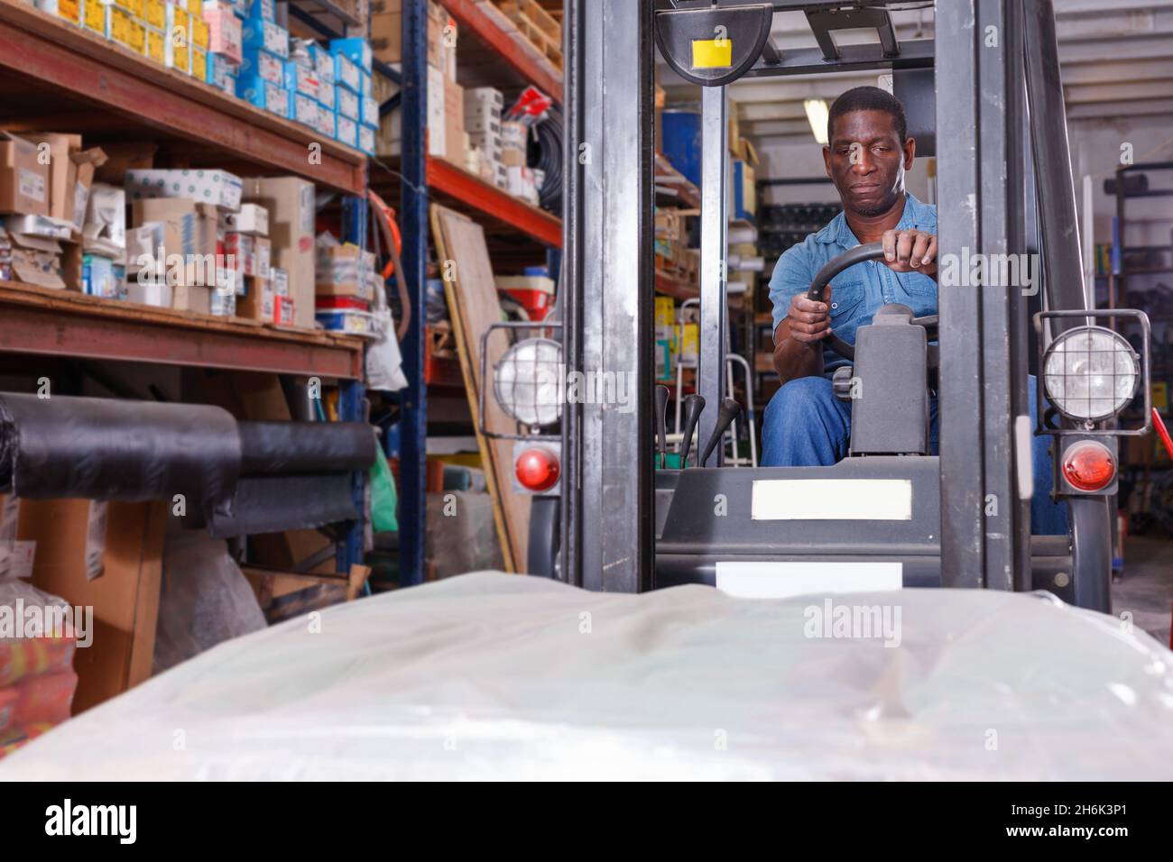 African American worker of building materials warehouse working on ...