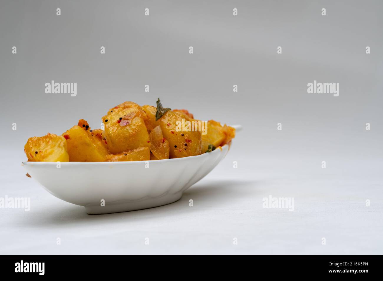 Sri Lankan spicy dry potato curry(devilled potatoes) isolated on white background. Stock Photo