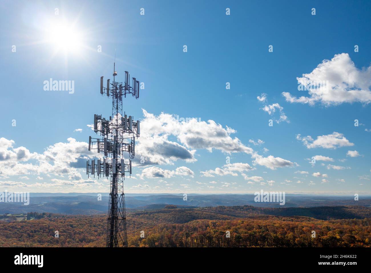 Aerial view of mobile phone cell tower over forested rural area of West