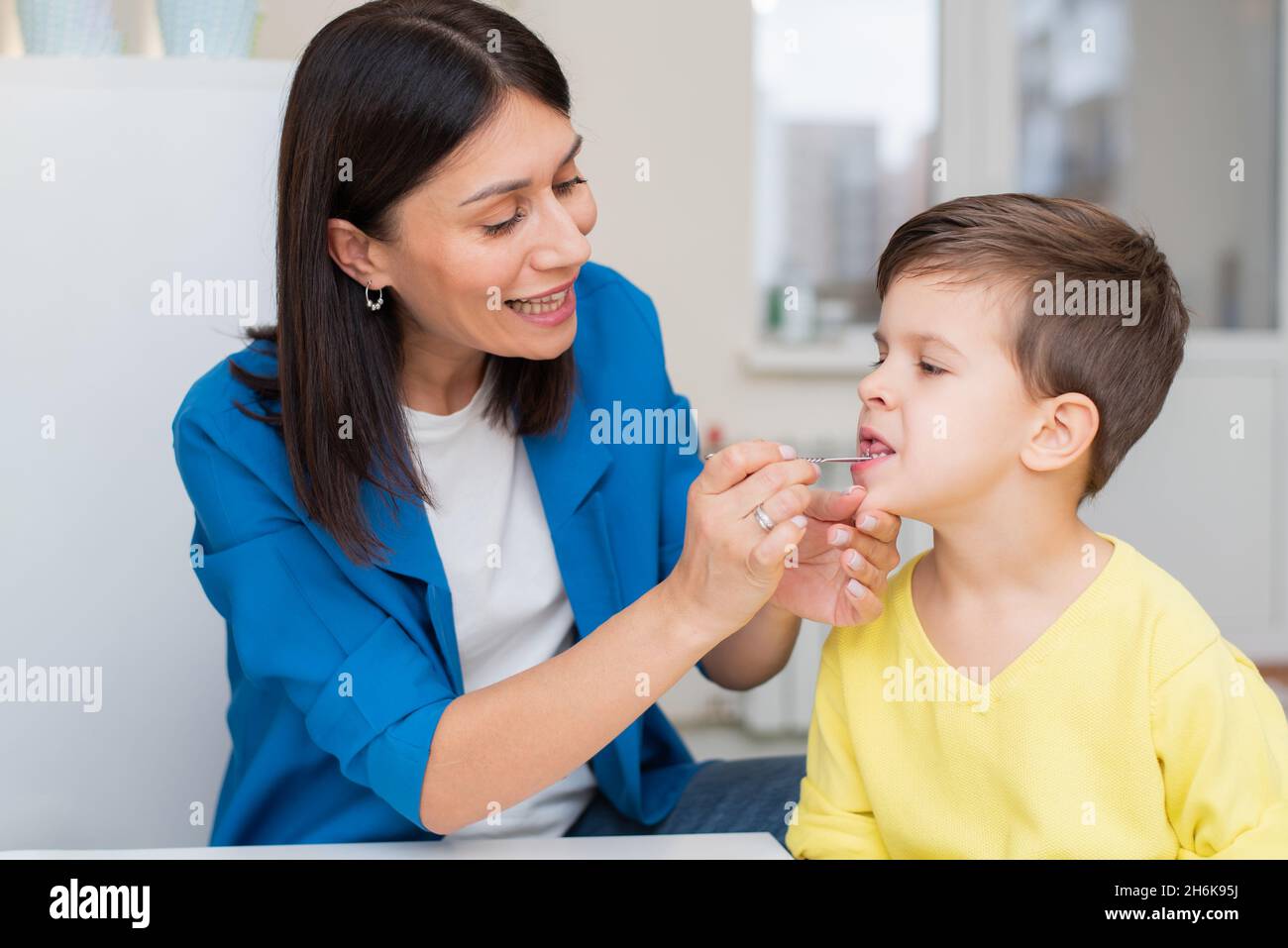 Woman develops the language of the child with a speech therapy probe