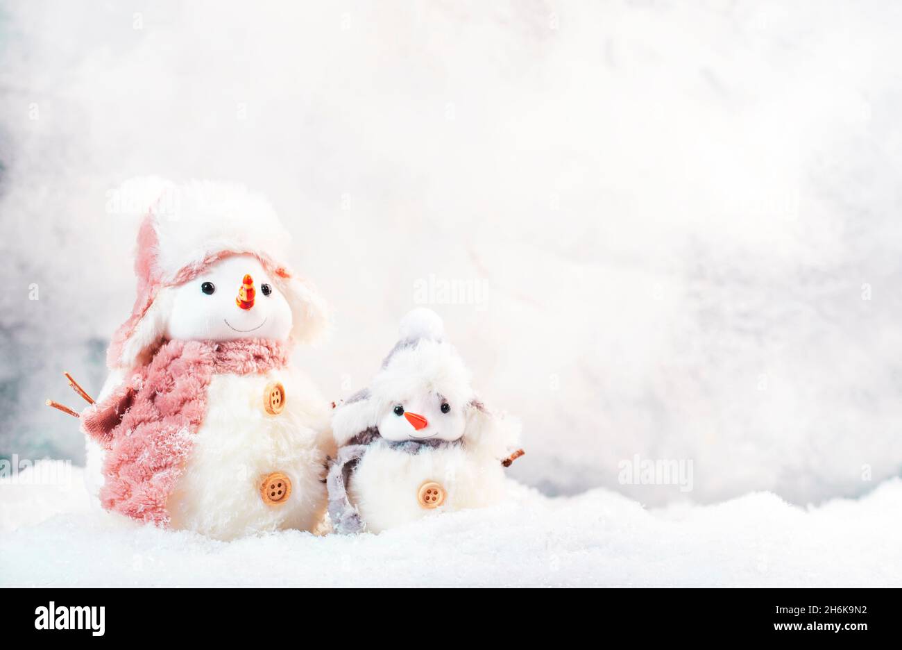 Christmas and new year snow concept with two cute snowmen in hats and ...