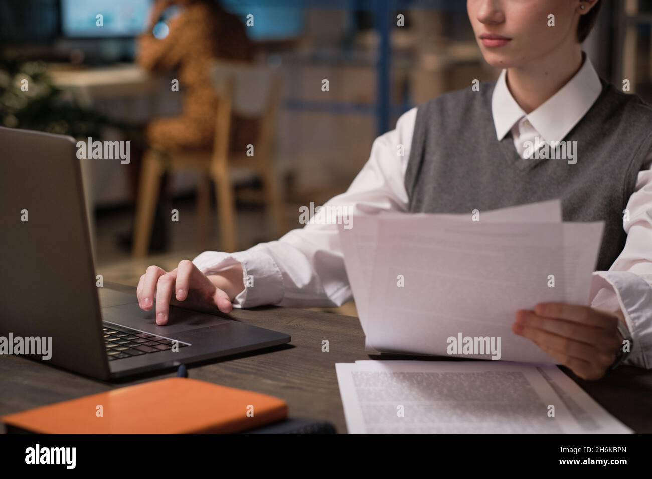 Young businesswoman working with documents using laptop at her workplace at office Stock Photo